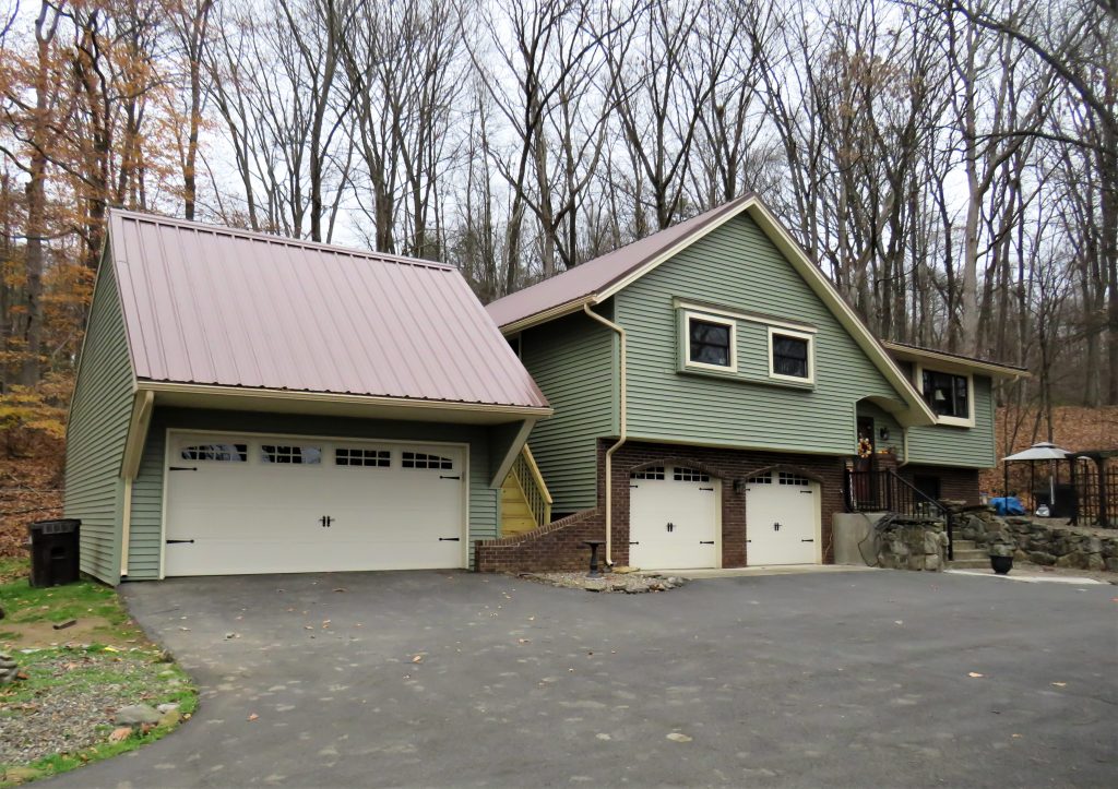 Front exterior of green house and garage after remodel.