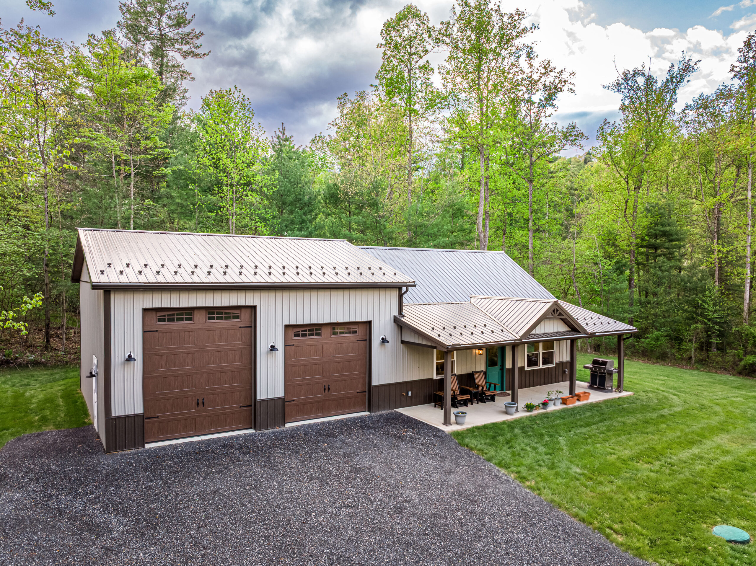 barndominium with white siding and brown trim and garage doors