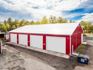 red pole barn with white garage doors