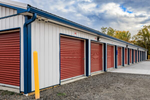 white pole barn with red roll doors for storage units