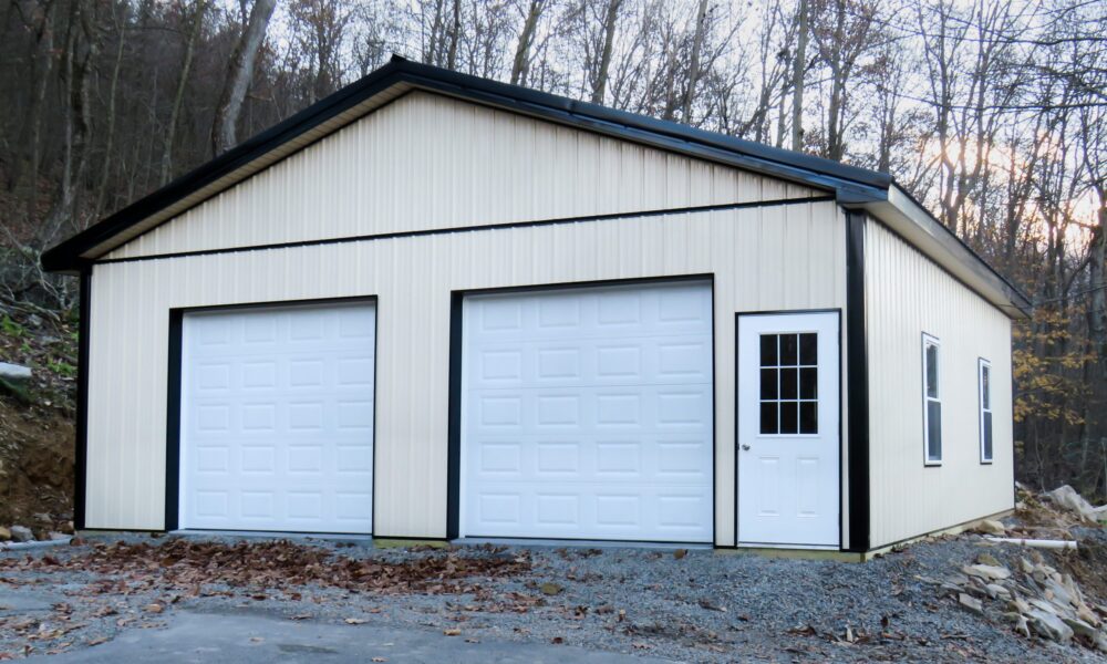 New pole barn with light siding and white doors.