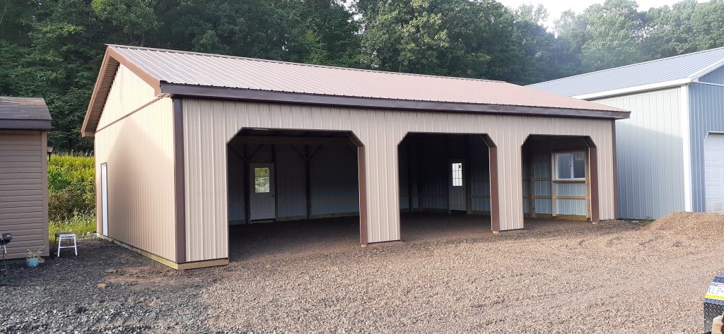 pole barn with tan metal siding, brown trim and tan metal roof