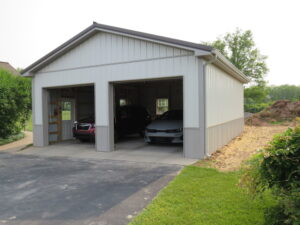 new gutter installation on a white detached garage, with gray gutters and downspouts
