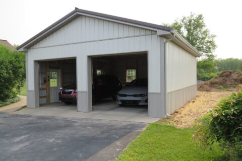 new gutter installation on a white detached garage, with gray gutters and downspouts