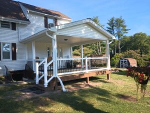 gutter installation for a new deck with roof, using white gutters and downspouts