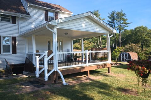 gutter installation for a new deck with roof, using white gutters and downspouts