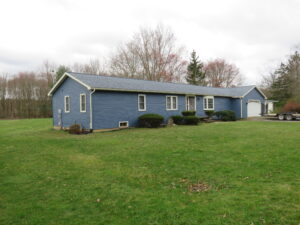 blue house with new roof, gutters, siding and trim. Uses white gutters and downspouts