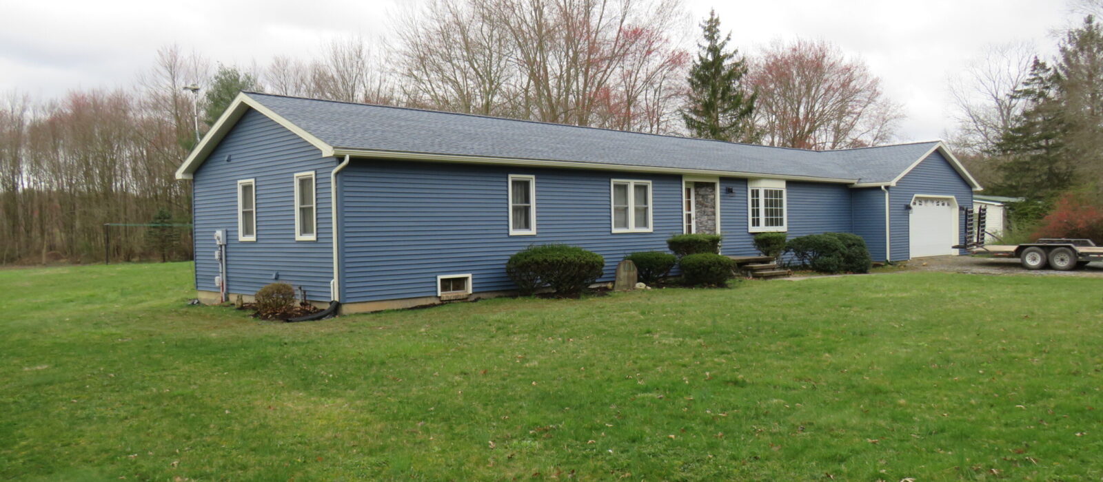 blue house with new roof, gutters, siding and trim. Uses white gutters and downspouts